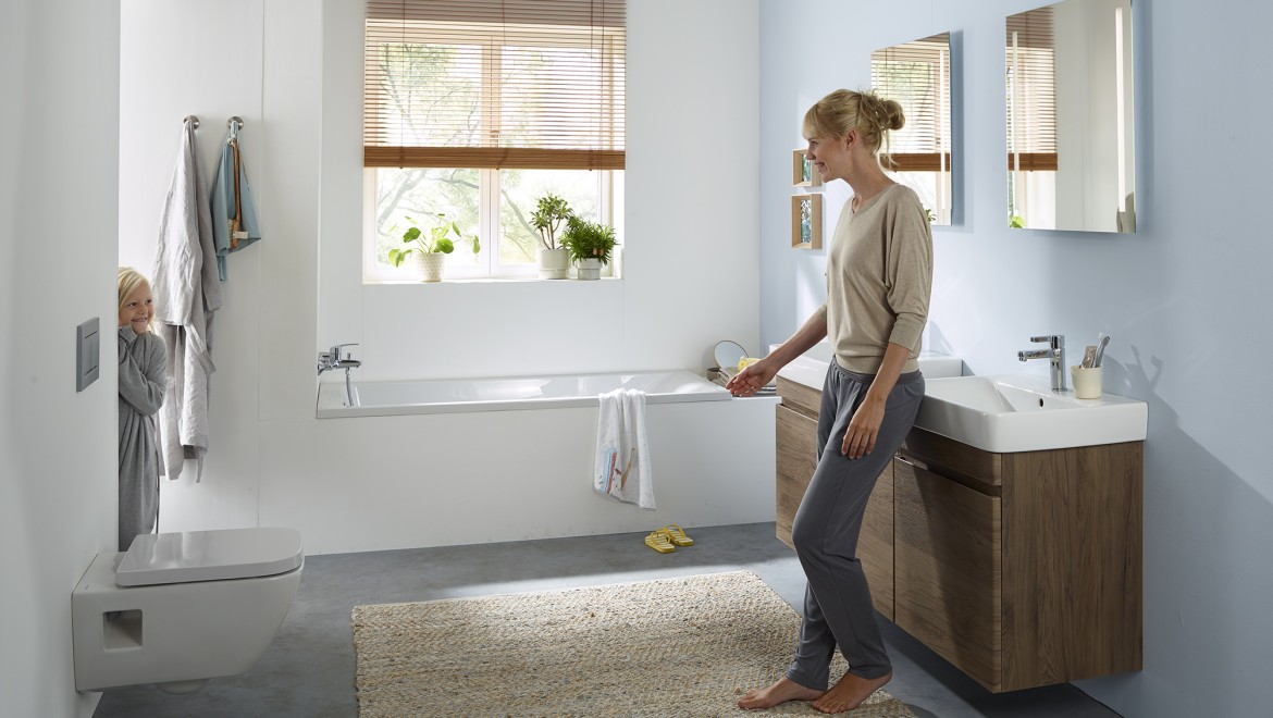 Woman and child standing in a Geberit Renova series family bathroom (© Geberit)