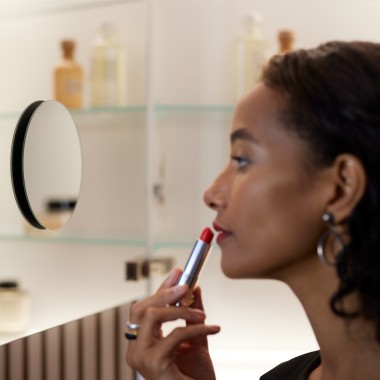 Woman applying make-up in the mirror