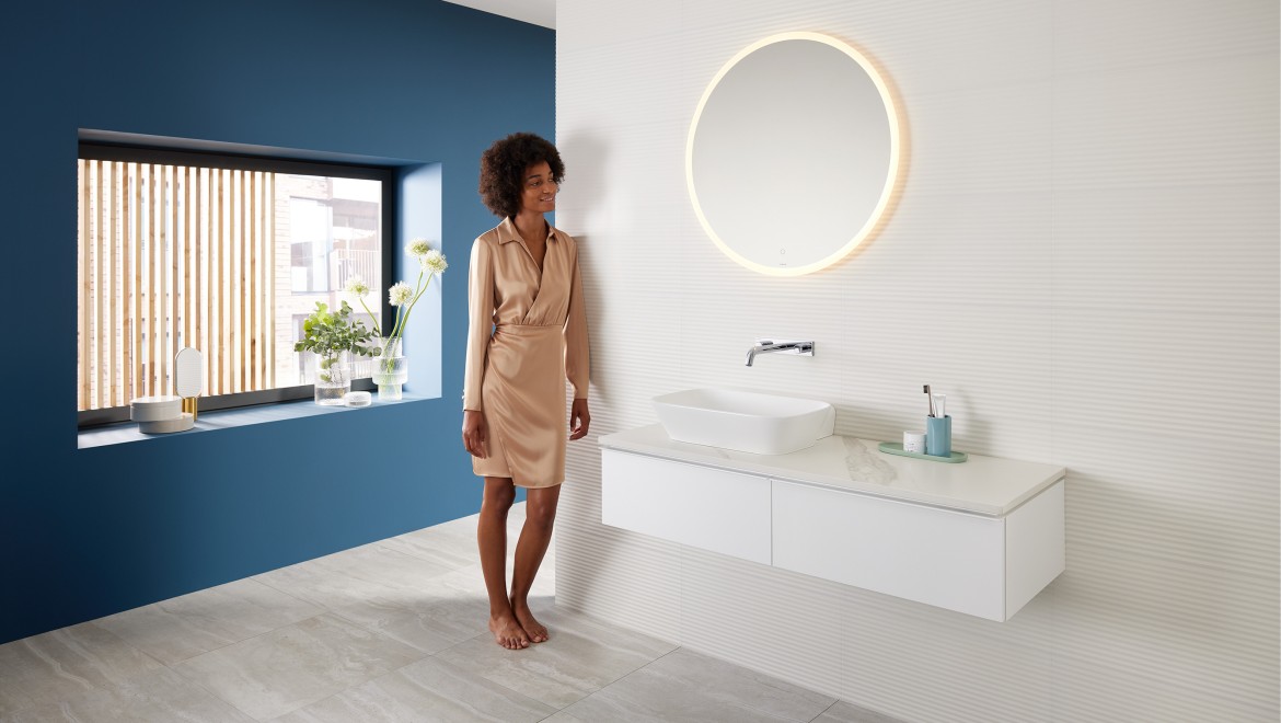 Woman standing in a bathroom created with the Mix & Match range from Geberit