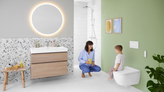 Woman and child in a bathroom with a Geberit AquaClean Alba shower toilet