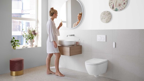 Woman in white bathroom with ceramic appliances and bathroom furniture Woman in white bathroom with ceramic appliances and bathroom furniture