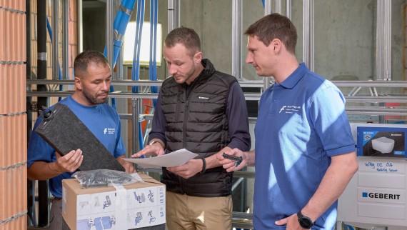 A Geberit sales representative advises plumbers on the construction site