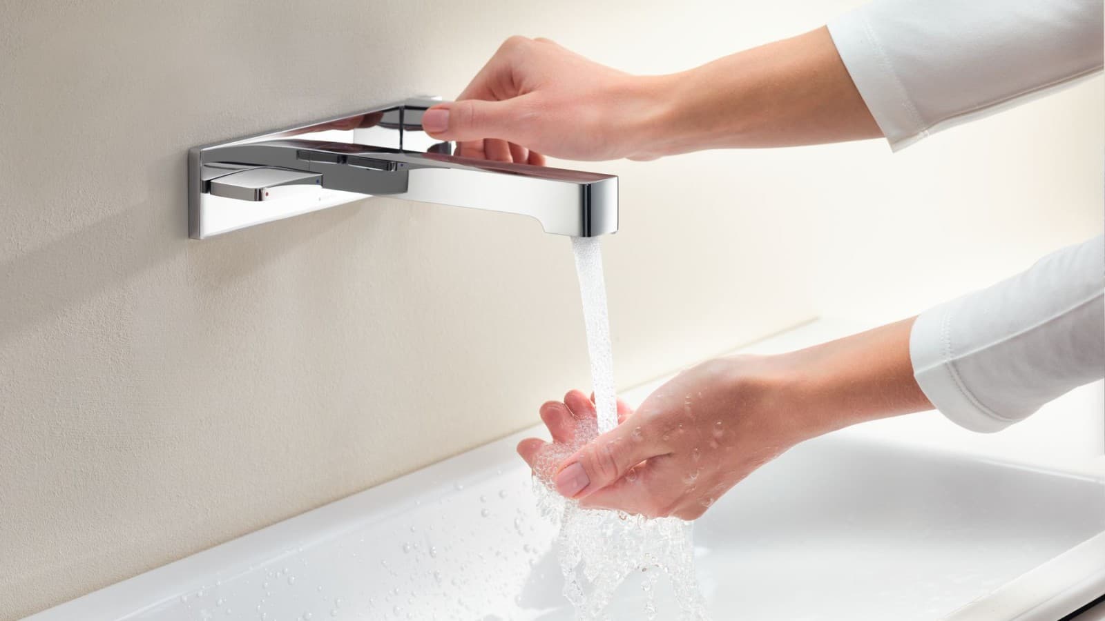 Macro image with hands turning a Geberit ONE tap and checking the water flow and temperature Macro image with hands turning a Geberit ONE tap and checking the water flow and temperature